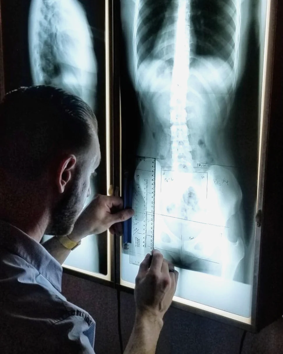 Dr. Ryan Nichols reviewing a patient’s spinal X-ray at SeaCoast Clinic