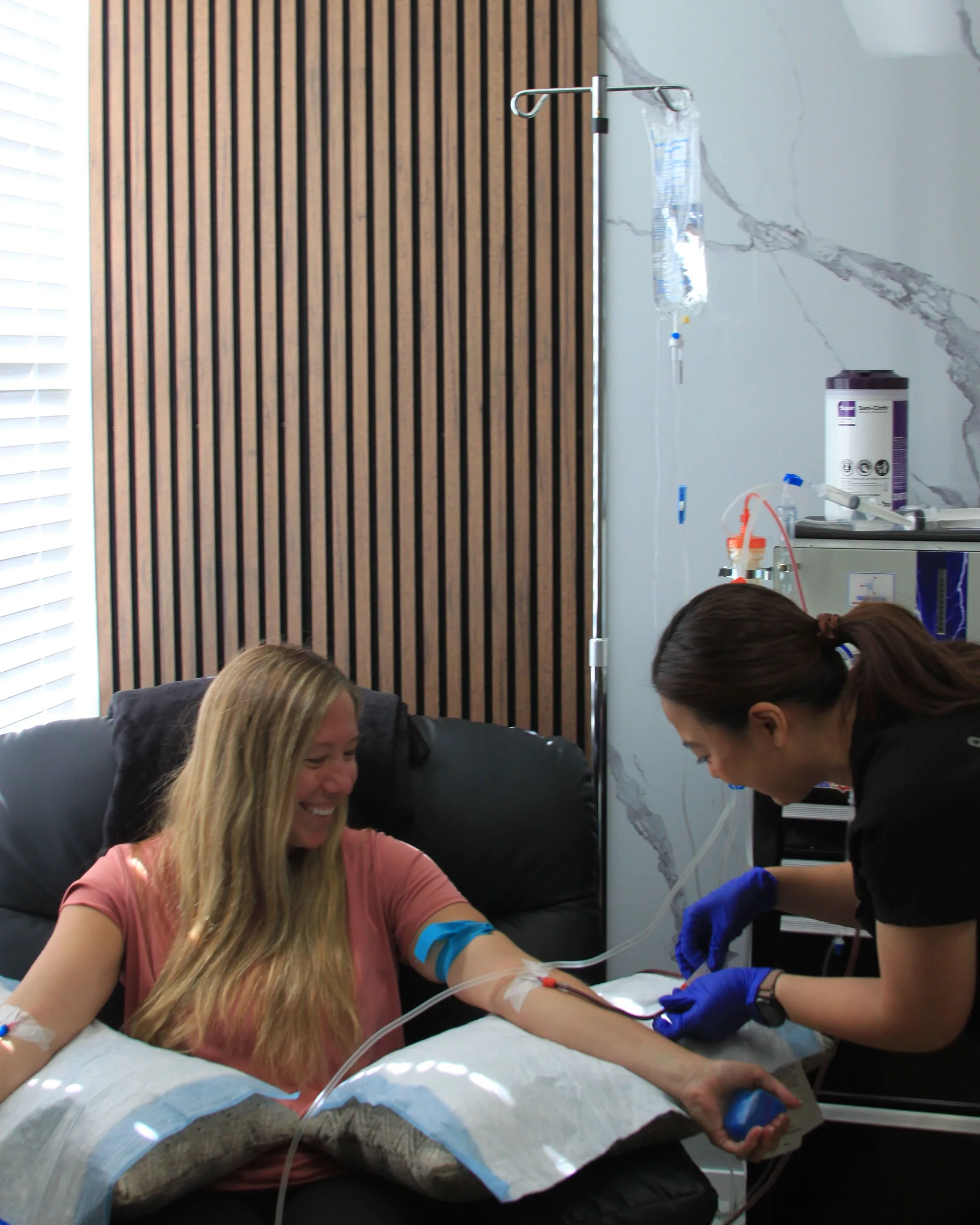 A clinician at SeaCoast Clinic placing an IV line for a patient in the treatment chair